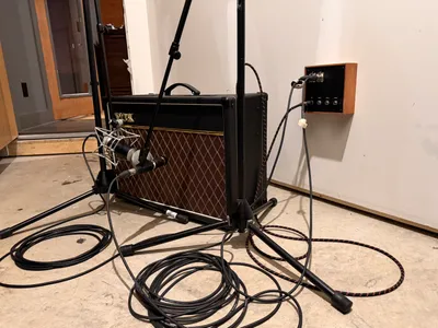 The amp closet. Vox AC15 miked up with a tie line panel on the wall