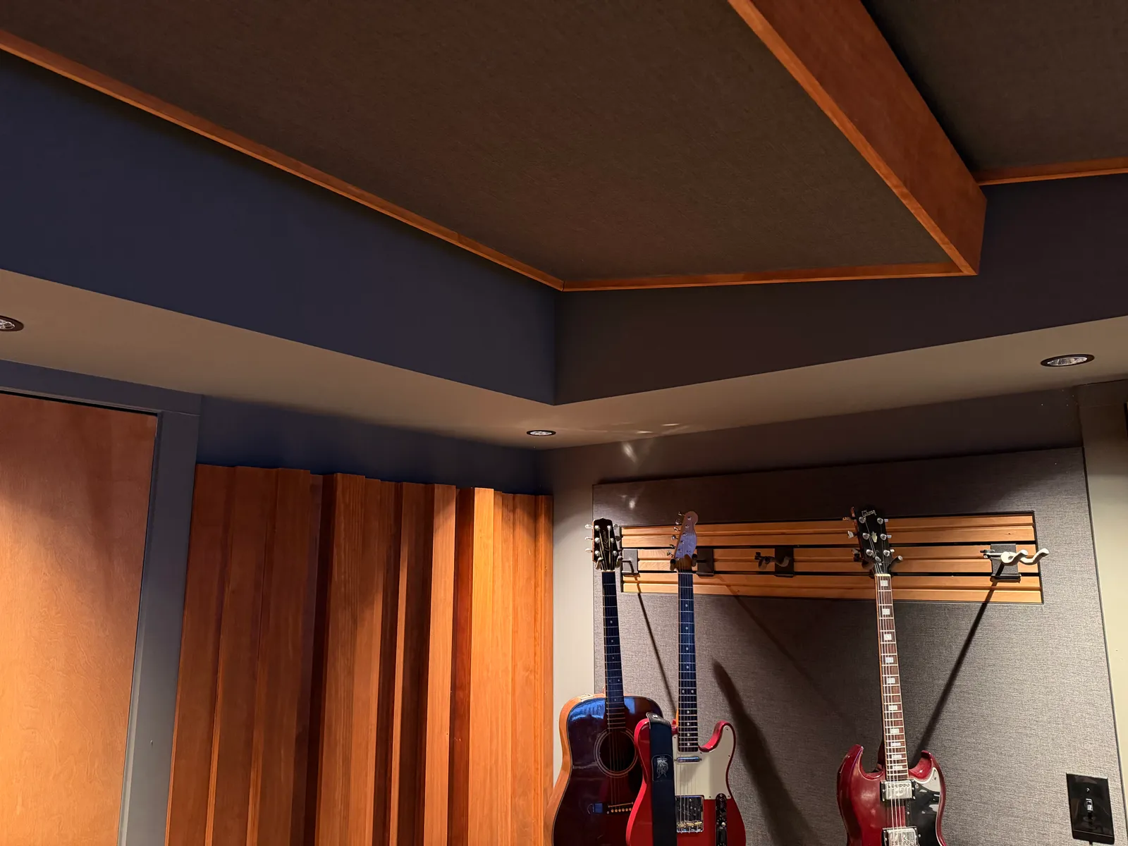 Ceiling acoustic panels and wood trim in the control room, guitars and diffusers below