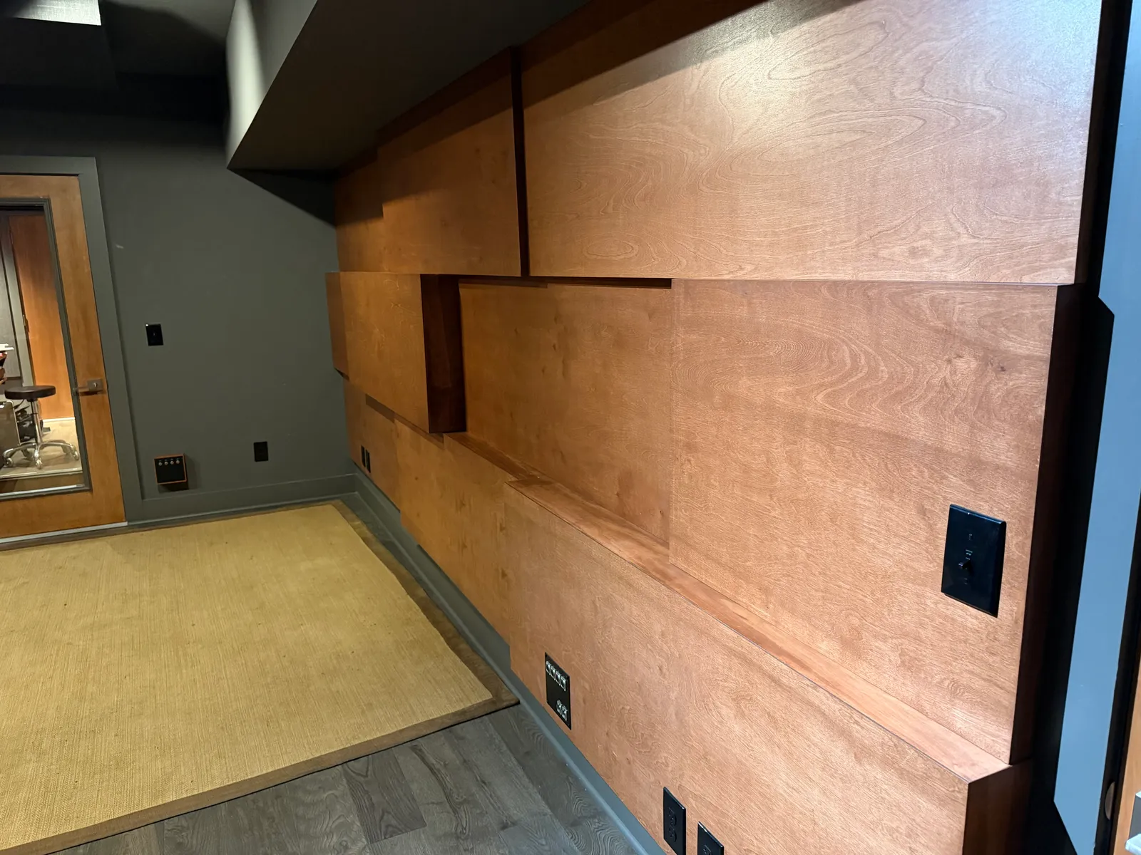 Custom wood paneling over tuned low-frequency absorbers: bass trapping built into the live room walls